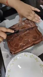 This is called a "Brownie" or a "Chocolate Brownie".

​It is a popular baked chocolate dessert that is rich, dense, and fudgy. The video shows someone cutting it into square pieces and lifting a slice, revealing a soft, gooey chocolate center topped with chocolate chunks.